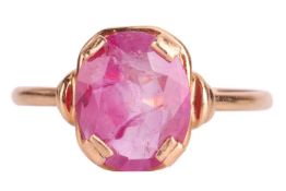 A ruby set ring. The mixed oval cut ruby in a simple four claw mount. The plain yellow metal stamped