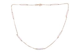 A cultured pearl and chain necklace, with eight four-pearl links evenly spaced throughout, on a yell