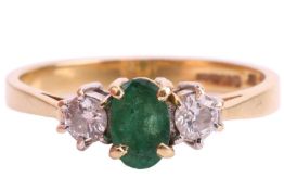 An emerald and diamond three-stone ring, set in 18ct gold, the central oval emerald measuring approx