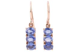 A pair of three-stone sapphire pendant earrings; composed of three oval cut sapphires in a claw-moun