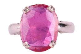 A single stone ruby ring; the oval mixed cut ruby in simple four caw mount to a carved gallery setti