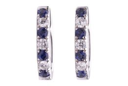 A pair of diamond and sapphire set hoop earrings, set with round brilliant cut diamonds with an esti