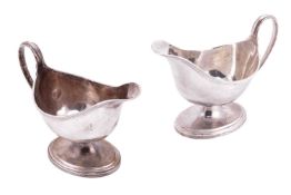 Elkington & Co.:- a pair of silver sauceboats of oval form with reeded rim, loop handle and foot