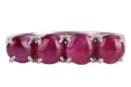 A star ruby four-stone ring. Each cabochon ruby measures 5.3mm x 2.2mm. Set to a plain white metal b