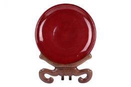 A very large Chinese sang de boeuf dish, 20th century, 53 cm diameter, with hardwood stand