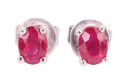 A pair of claw-set ruby stud earrings, the 18ct white gold mounts set with oval mixed cut rubies, of