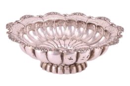 A large pedestal bowl, of oval form with gadrooned sides, everted rim decorated with pierced and cas