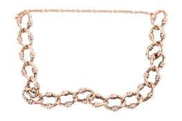 A fancy link bracelet with safety chain, missing the clasp. The yellow metal is un-hallmarked but te