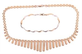 A gold fringe necklace and a two tone gold bracelet; the gold panther link fringe necklace measuring
