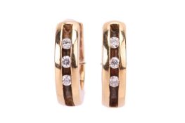 A pair of diamond-set huggy earrings in 18ct yellow gold, channel-set with three diamond accents, Sh