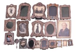 Nineteen various silver photograph frames and a small silver backed mirror.