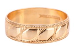 An 18ct gold band ring, with a textured panel pattern throughout. Hallmarks for 18ct gold to the ins