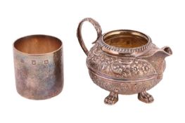 A Victorian cream jug, circular with gadrooned borders and heavily repoussé worked sides with scroll