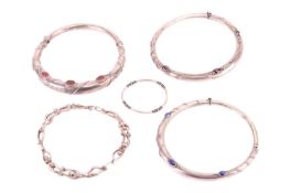 A group lot of jewellery in white metal. To include two red hardstone set hinged collar necklaces on