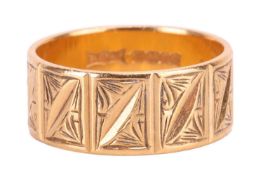 A 22ct gold wedding band ring. The ring is decorated with textured panels throughout, with full Engl