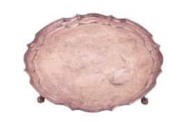 A silver salver; with pie crust edged and on four leaf-mounted scroll feet. Sheffield 1938 by John T