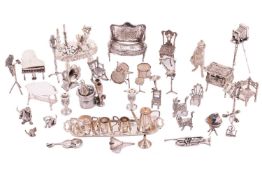 A collection of silver and white metal figures comprising a silver bow-fronted sofa decorated with f