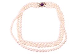 A three-strand cultured pearl necklace, comprising three rows of graduating round pearls with cream 