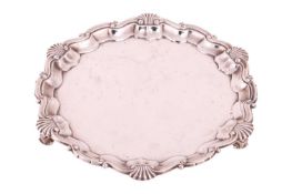 A silver salver by Goldsmiths and Silversmiths Company, London 1916, with piecrust and shell rim, on