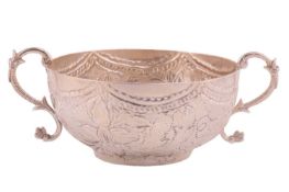 A 17th-century style white metal porringer, the flat chased decoration in the form of stylised flowe