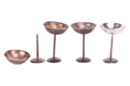 A set of four champagne coupes, shallow circular bowls supported on a straight stem and round foot, 
