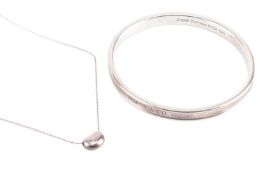 Tiffany & Co. - an 1873 closed bangle and an Elsa Peretti bean charm on chain; the bangle struck