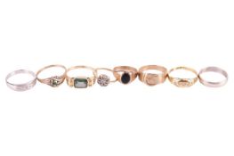 A collection of eight assorted rings, comprising a 9ct gold buckle ring, ring size N 1/2, an unmarke