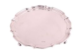 A silver salver, Sheffield 1923, by James Deakin & Sons, with piecrust edge on four feet, measur