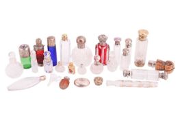 A collection of cut glass scent bottles, many with silver mounts, one featuring an enamel portrait c