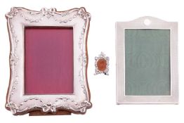 A collection of three silver photo frames; including an Edwardian silver photo frame with bow and ga