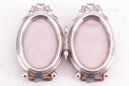 An Edwardian silver duet photo frame, the hinged frames with bow decoration, each measuring 9 x 5.5c