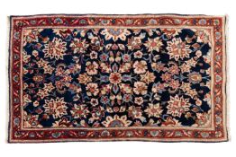 A small dark blue ground Kerman rug, contemporary, with palmette and floral spray design within a me