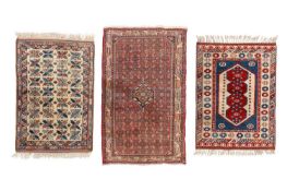 A small ivory ground Kazak rug with a field of holly leaves, within a serpent and baton border, meas