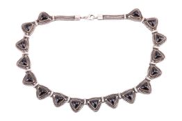 A silver necklace set with 17 triangular Whitby jet cabochons, bordered with foxtail link chains, co