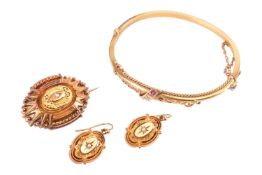 A collection of Victorian Etruscan revival style jewellery; comprising a hinged bangle set with an o