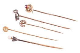 A collection of five diamond and seed pearl stick pins; including a rose cut diamond key pin (one di