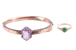 A Victorian amethyst hinged bangle in 9ct gold, claw-set with an oval-cut amethyst of light purple c