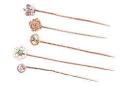 A collection of five stick pins, to include an old-cut diamond within an annular surround, another o