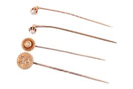 A collection of four diamond set stick pins; comprising an old cut diamond pin, the diamond with an 