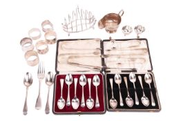 A quantity of silver items comprising a toast rack, hallmarked London, 1925, a cream jug, seven suga