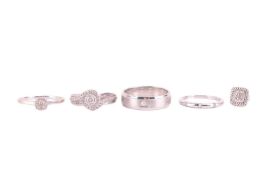 A collection of diamond rings, including a diamond cluster ring, set with a central round brilliant 
