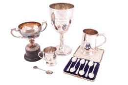 Two silver trophy cups, two mugs, a cased set of six golf interest teaspoons, and a loose novelty sp