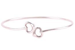 Tiffany & Co. - a double open heart bangle by Elsa Peretti, wire bracelet terminated with heart 