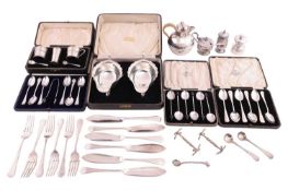 A cased set of two silver sauceboats, two sets of cruets, loose condiment spoons, a cased of six cof