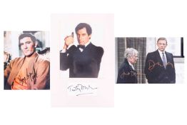James Bond: a collection of three signed photographs, comprising Daniel Craig & Judi Dench, Geor