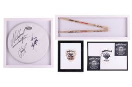 Motörhead: a group of signed and framed items, comprising a drumskin, with the signatures of Lemmy K