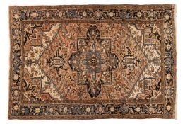 A muted red ground Heriz carpet, 20th century, with a typical geometric book cover design within a t