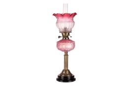 A vaseline and cranberry tinted pedestal oil lamp with an acid printed diffuser, measuring 70 cm tal