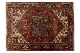 A brick red ground Heriz rug, 20th century with a typical central geometric star within heavily styl