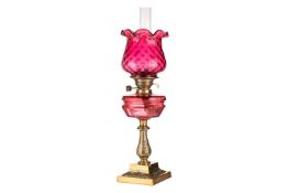 A Hinks & Co Type cranberry glass duplex pedestal oil lamp with dimpled cranberry diffuser, meas